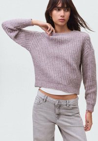 Svetlo vijoličen pleteni pulover z širokim izrezom, skrajšanega kroja in teksturiranim vzorcem, v kombinaciji s svetlo sivo obleko.