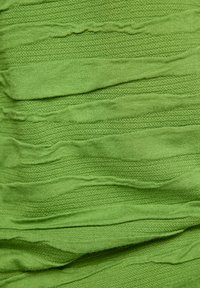 Grüner Stoff mit abwechselnd glatten und strukturierten horizontalen Rippstreifen, die ein wellenförmiges Muster erzeugen.