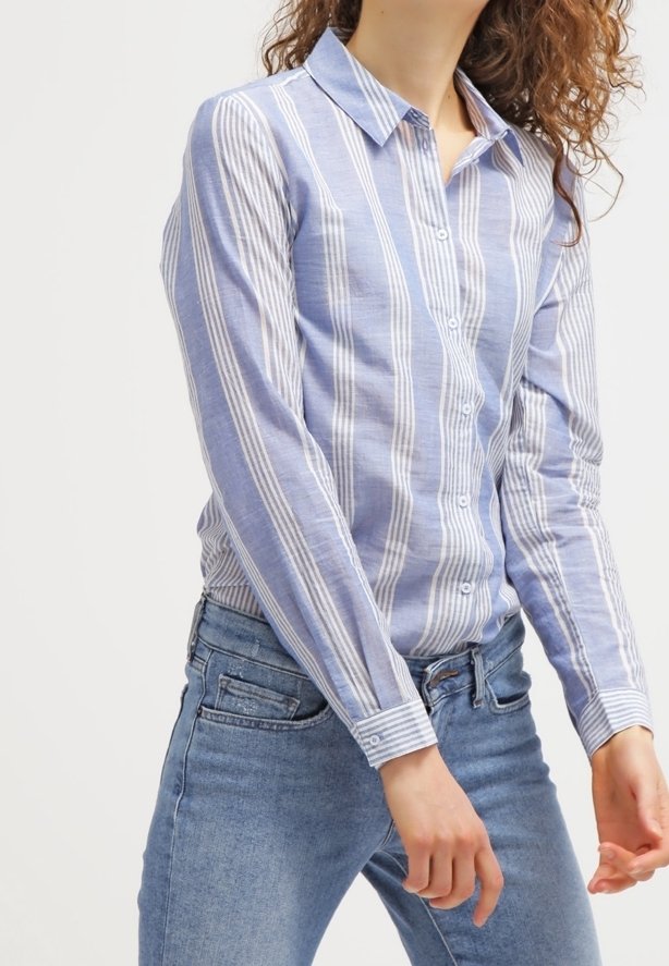 Hellblaue Button-Up-Bluse mit weißen vertikalen Streifen, Kragen, langen Ärmeln, aus Baumwolle oder Leinen, kombiniert mit Jeans in mittlerer Waschung.