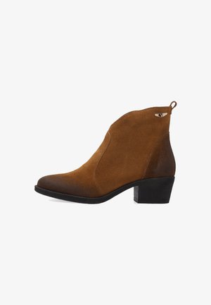 Braune Wildleder-Ankle-Boots mit spitz zulaufender Zehenpartie, Blockabsatz und seitlicher Zuglasche. Eigenschaften sind einfarbige Farbvariation und ein kleiner metallischer Akzent.