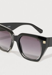 Óculos de sol pretos de plástico com armação quadrada, lentes graduadas e um pequeno logótipo dourado no lado. Acabamento brilhante e hastes largas.