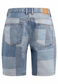 Denim shorts in varying shades of blue with a patchwork design. Features two back pockets and a leather tag at the waistband.