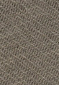 Tela de algodón caqui con una textura acanalada, que presenta finas líneas horizontales. El color es una mezcla de beige y verde oliva.