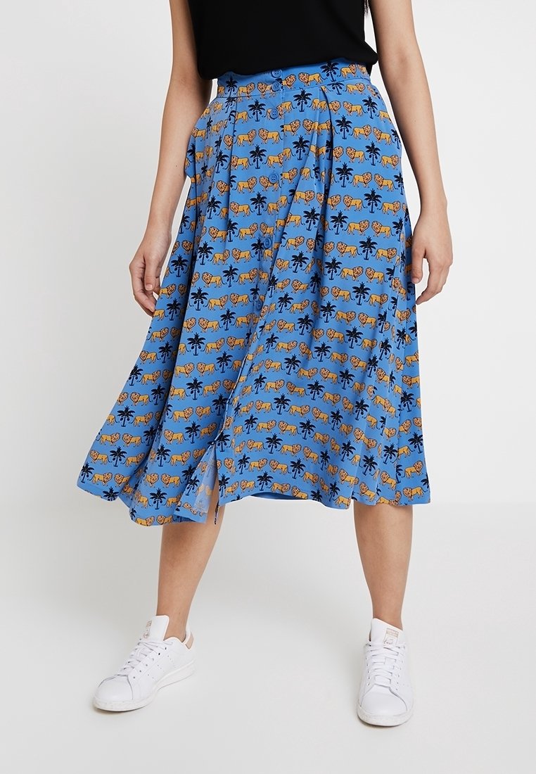 Jupe midi bleue avec un motif répétitif de tigres et de palmiers, design plissé, tissu léger et une légère fente latérale.