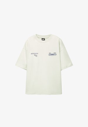 Svijetlozelena oversized majica od pamuka, s grafičkim printovima u tamnoplavoj boji na prednjoj strani, okruglim izrezom i kratkim rukavima.