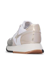 Sneaker con tomaia bianca e beige, caratterizzata da un accento dorato lucido, dettagli in suede e una suola in gomma testurizzata con scanalature.