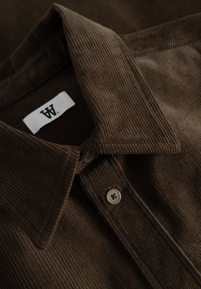 Brown corduroy shirt featuring a button-down collar, textured fabric, two buttons on the front, and a white brand tag.