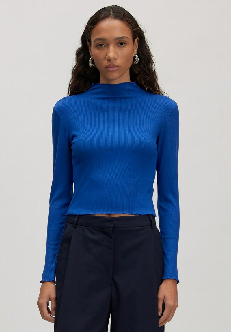 Gekürztes, langärmliges Oberteil aus leuchtend blauem Rippstoff mit einem Stehkragen-Design. Verfügt über rohe Kanten am Saum und an den Manschetten.