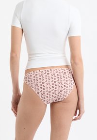 Krótka bawełniana bielizna z różowym tłem, ozdobiona powtarzającym się wzorem wiśni w odcieniach fioletu i zieleni. Wysoki stan.