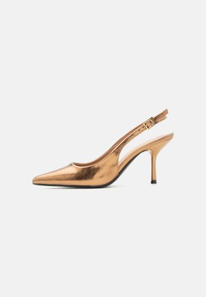 Fényes bronz színű hegyes orrú slingback magassarkú cipő közepes magasságú tűsarokkal és állítható csatos pánttal világos háttéren.