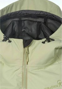 Beige takki, jossa on keskellä vetoketju, musta verkkomateriaali sisävuorina ja säädettävät naru- ja solkikiinnikkeet kaulan alueen molemmin puolin.