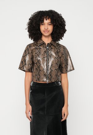 Top cropped de mangas curtas em padrão de pele de cobra falsa com brilho metálico, apresentando um fecho de correr frontal e colarinho, combinado com uma saia preta texturizada.