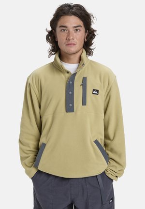 Fleece pullover in lichtgroen, met grijze accenten, een halve knoopsluiting en een ritszak. Zachte textuur met zijzakken.
