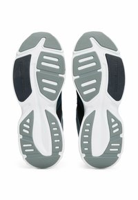 Scarpe da ginnastica nere con suole in gomma bianche e grigie. La suola presenta numerose scanalature e ritagli per una migliore aderenza e flessibilità.