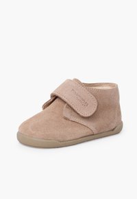Child's beige suede shoe with adjustable Velcro strap and rubber sole, designed for comfort and easy fastening.