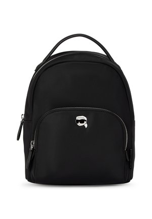 Sac à dos noir avec poche à zip avant, poignée supérieure et petit logo argenté représentant un visage stylisé portant des lunettes de soleil et une queue de cheval.