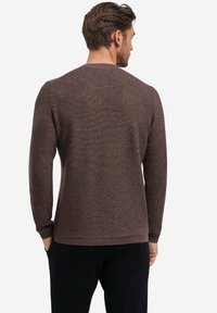 Brauner, strukturierter Pullover mit Rundhalsausschnitt, langen Ärmeln sowie geripptem Saum und Bündchen, entworfen für eine taillierte Silhouette.