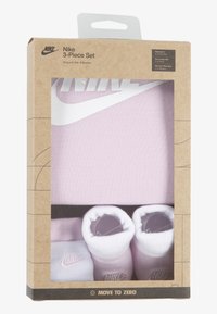 Nike set od tri dijela koji uključuje svijetloružičasti bodysuit, odgovarajuću kapicu i botice. Pakiranje je od smeđeg kraft papira s prozirnim prozorom.