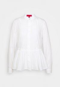 Blusa bianca a maniche lunghe con colletto alla cinese, bottoni frontali e vita arricciata, caratterizzata da un orlo a peplum e tessuto di cotone morbido.