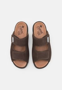 Braune Wildledersandalen mit zwei verstellbaren Klettverschlüssen, Lederinnensohle und kontrastierenden Nähten, die ein abgerundetes Offene-Zehen-Design aufweisen.