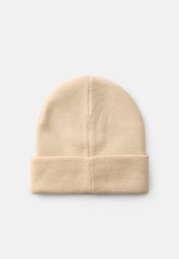 Gorro de malha bege com uma textura suave, apresentando um punho dobrado e um topo arredondado, feito de um tecido quente e elástico.