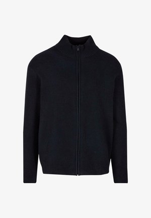 Juodas užtrauktuku užsegamas megztinis su aukštu banguotu kaklu, ilgomis rankovėmis ir banguotu apačiu. Pagamintas iš minkštos, tekstūruotos medžiagos. Paprastas, minimalus dizainas.