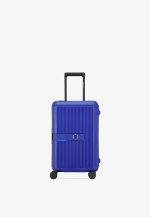 Maleta rígida azul con estrías verticales, cuatro ruedas negras, asa negra retráctil y correa horizontal central con detalle circular.