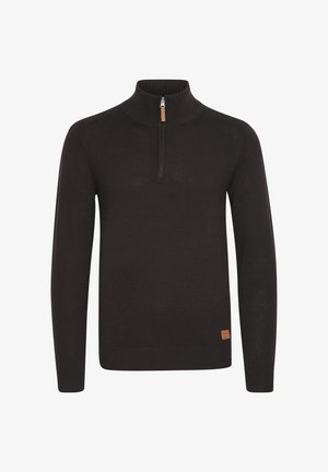 Tumepruun lukk-kaelusega sveter, mis on valmistatud pehmest kangast. Sveteril on ribades kaelus ja mansetid, ning kuuletõud kaeluses väike nahkplekk.