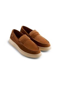 Scarpe slip-on in suede marrone con punta arrotondata, dotate di cuciture decorative e una suola in gomma chiara. Logo discreto di marca sul lato.