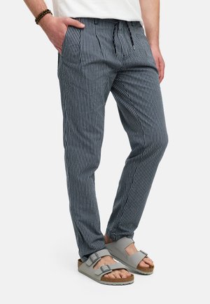 Blå och vita randiga lätta byxor med resårmidja och dragsko, med sidofickor och parat med grå sandaler.