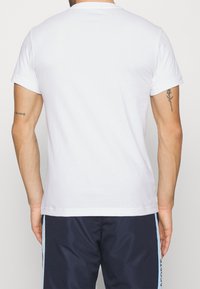 White short-sleeve T-shirt in cotton with a crew neckline, featuring a smooth texture and no visible patterns or accents.