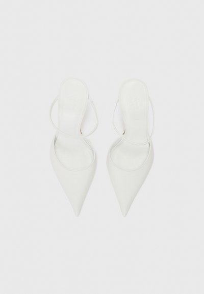 Bílé lodičky na vysokém podpatku s špičatou špičkou a designem slingback. Hladká kožená materiál a minimální detaily šití. Plná podrážka.