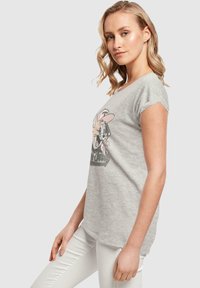 Grå bomulls t-skjorte med rullet kort arm, med et grafisk motiv av en tegneseriefigur i svart og rosa, formet med en avslappet passform.