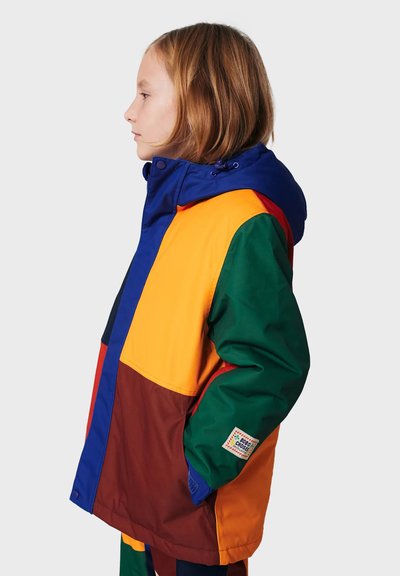 Doudoune colorée avec un mélange de panneaux bleus, orange, verts et marron. Comprend une capuche et une étiquette sur la manche.