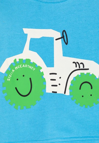 Sinine dressipluus, millel on valge traktorigraafika, rohelised naeratava näoga rattad ja tekst "STELLA MCCARTNEY" kaardus fondis.