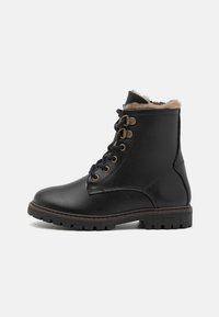 Botas de tobillo de cuero negro con forro de pelo sintético, ojales en tono dorado y cordones negros. Suela de goma gruesa con una textura para mayor agarre.