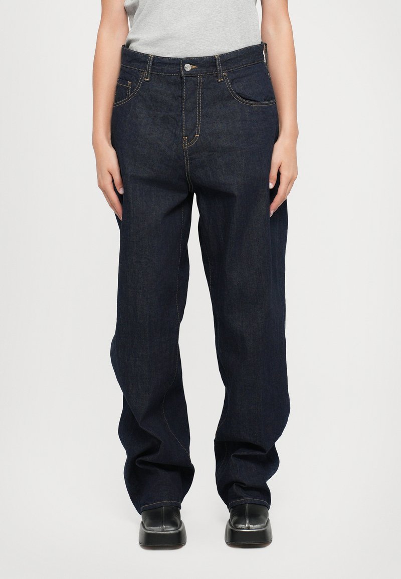 Temno modri denim kavbojki z udobnim krojem, z zlatimi šivi, petimi žepi in gumbom za zapiranje na pasu.