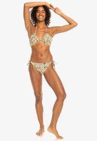 Bikini-set med blommönster i gult, rosa och grönt. Toppen har en triangulär design och underdelen knyts i sidorna.