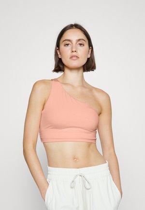 Top cropped assimétrico de um ombro só em tecido rosa suave. Textura suave com um design ajustado, apresentando uma cintura larga para maior conforto.