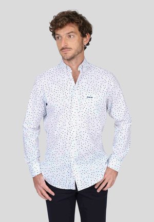 Chemise blanche à boutons avec de petits motifs géométriques multicolores, dotée d'un col, de manches longues et d'une poche poitrine.