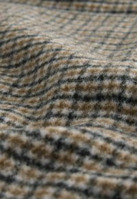 Wool fabric featuring a checkered pattern in shades of brown, beige, and black, with a soft texture and a slightly fluffy appearance.