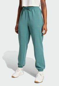 Türkisfarbene Jogginghosen aus weichem Material, mit einem elastischen Bund und Kordelzug, schmal zulaufenden Bündchen und einem dezenten Logo-Akzent am Bein.