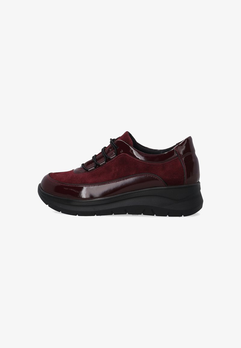 Burgunderfarbene Damensneaker mit Obermaterial aus Wildleder und lackiertem Leder, schwarzen Schnürsenkeln und dicker schwarzer Gummisohle, Seitenansicht auf weißem Hintergrund.