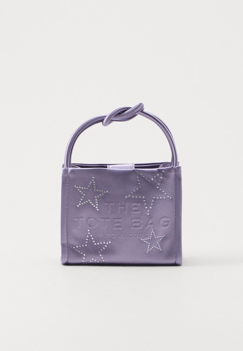 Bolsa de tote de satén morado con un asa anudada, texto en relieve y patrones de estrellas adornados con pequeñas tachuelas plateadas. Forma cuadrada compacta.
