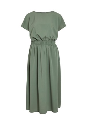 Žalia, iki kulkšnių siekianti suknelė su apvaliu iškirpimu ir trumpomis rankovėmis. Yra elastinga juosta ir lygi, lengva medžiaga. Be raštų.