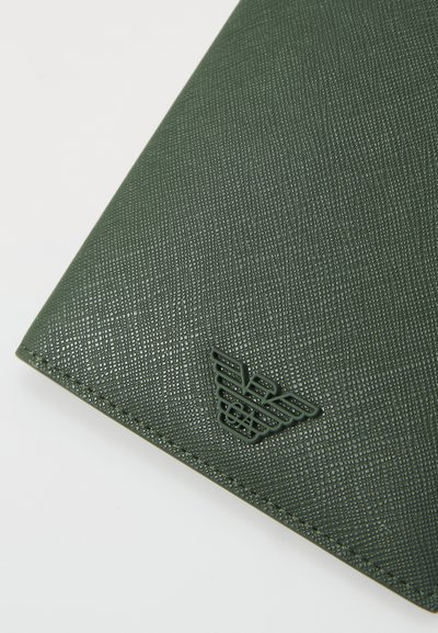 Portofel verde texturat, fabricat din material sintetic, cu o suprafață cu model. Prezintă un logo embosat proeminent într-un colț.