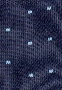 Morska tkanina z małym, jasnoniebieskim wzorem w kropki. Tekstura jest prążkowana, co zapewnia rozciągliwość i komfort. Wzór jest prosty i jednolity w całej długości.