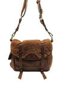 Sac en cuir suédé marron avec un rabat en shearling marron texturé. Doté de sangles en cuir ajustables, de quincaillerie en métal et d'une fermeture sécurisée avec des boucles.