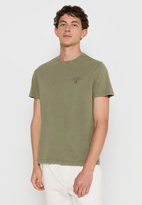 Olivenfarvet bomulds T-shirt med rund hals, korte ærmer og subtile trykte detaljer på brystet. Enkel, afslappet design; blød tekstur.