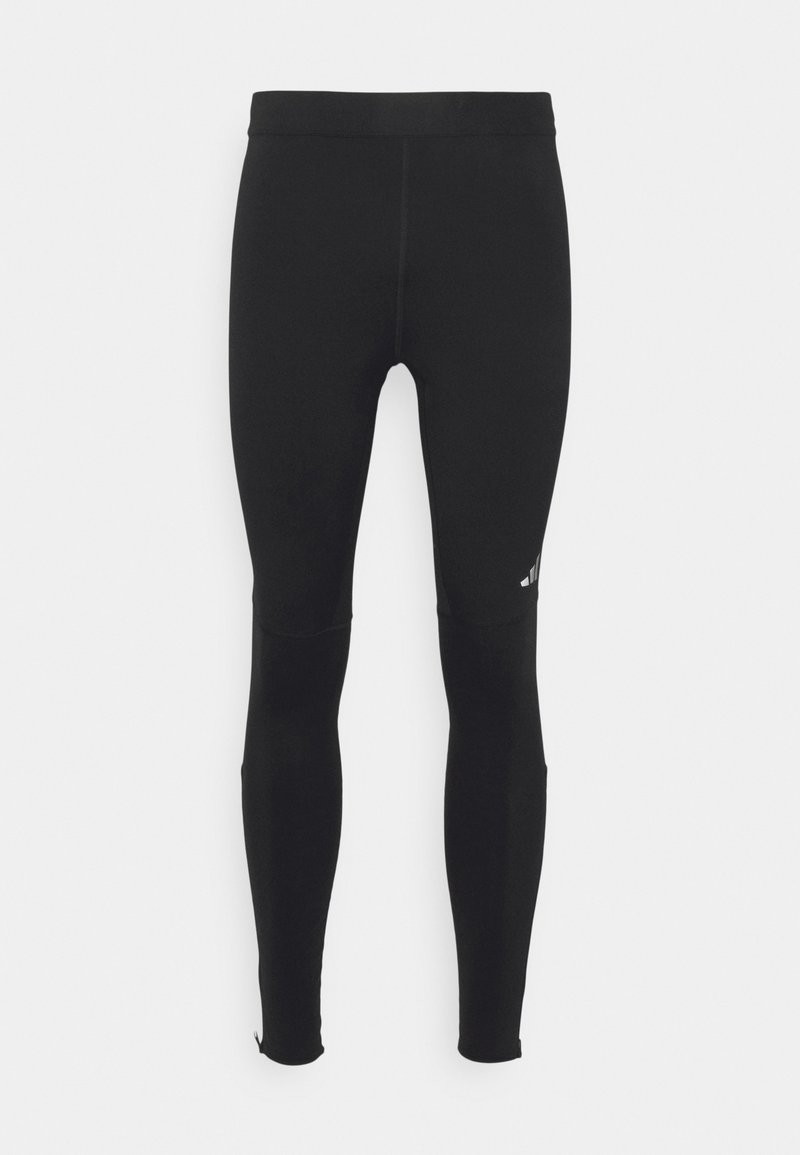 Zwarte sportleggings met een soepele textuur, een aansluitende pasvorm, elastische tailleband en subtiele logo-detail op de bovenbeen.
